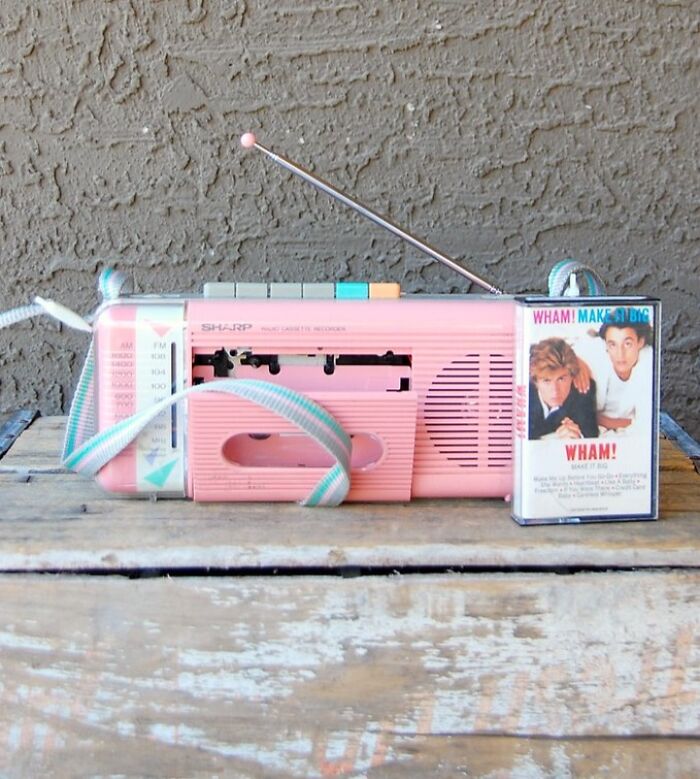 Pink retro tech boombox with a Wham! cassette tape, a perfect example of 80s glorious weirdness.
