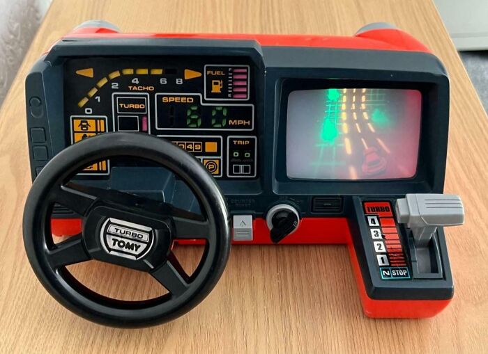 A Turbo Tomy retro tech racing game from the '80s, featuring a steering wheel and gear shifter.