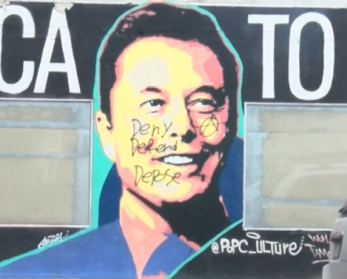 Graffiti art depicting Elon Musk with text and an anarchy symbol, representing an Eat The Rich moment.