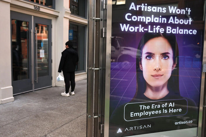 A photo of a street showing a person next to a digital advertisement with a sad world tone.