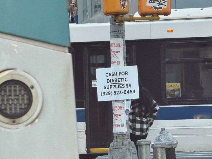 A sign offering cash for diabetic supplies on a street pole, reflecting the sad world of medical needs and financial struggles.