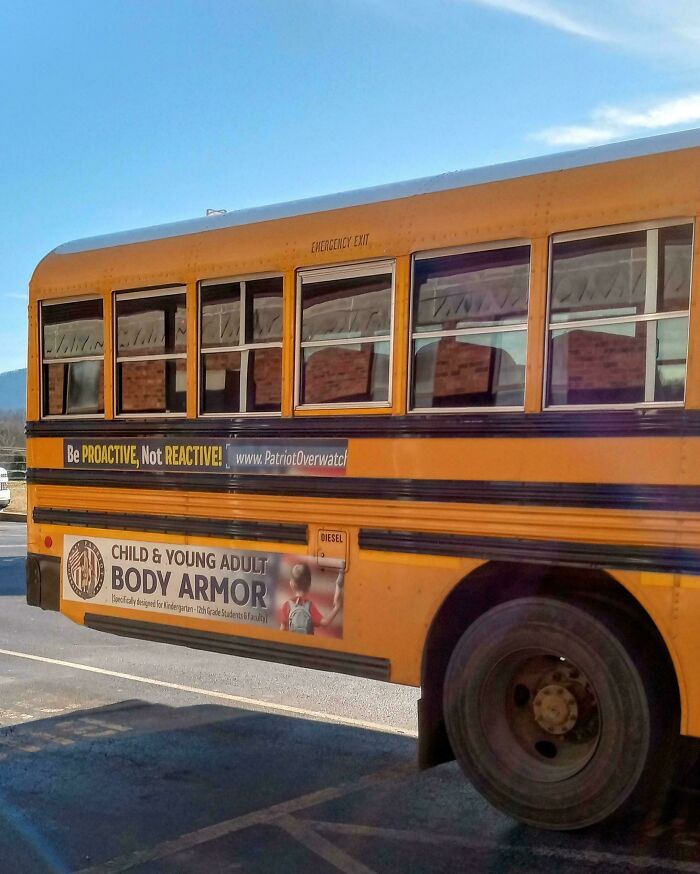 A yellow school bus with an advertisement for child and young adult body armor, revealing a horrid world.