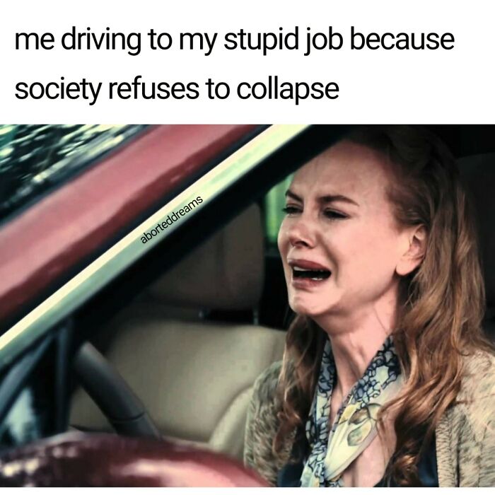 A woman crying while driving, expressing a feeling of driving to a stupid job in a horrid and sad world.