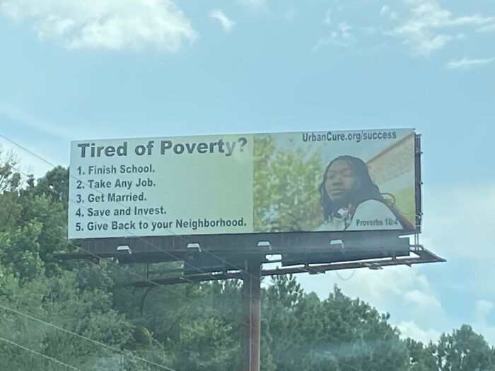 A billboard offering solutions to poverty, reflecting the horrid world's struggles.