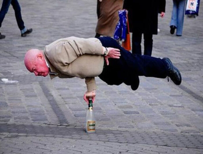 An elderly man levitating horizontally, balancing on one hand on a bottle, a baffling image that seems to make absolutely no physical sense.