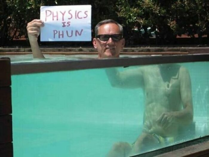A man in a pool holding a sign that says PHYSICS IS PHUN. The baffling image shows his body distorted by water refraction, making absolutely no physical sense.