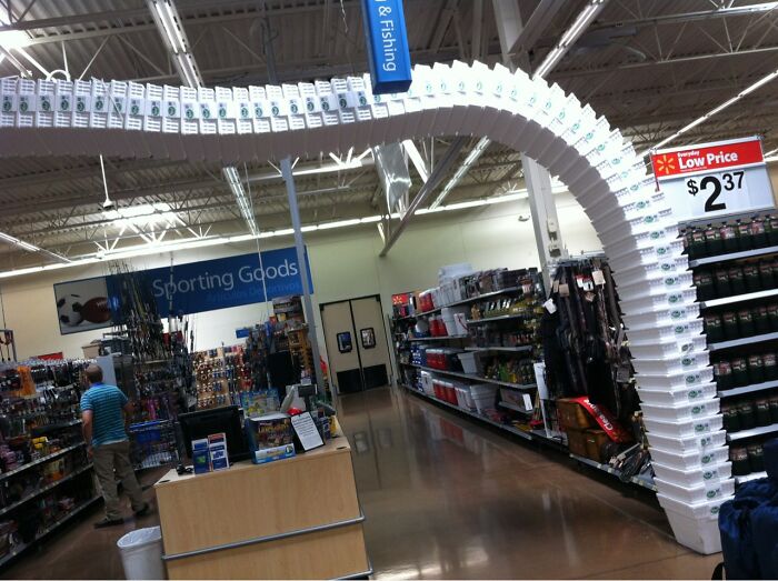 An archway made of white boxes spans an aisle in a store, creating a baffling image in the sporting goods section.
