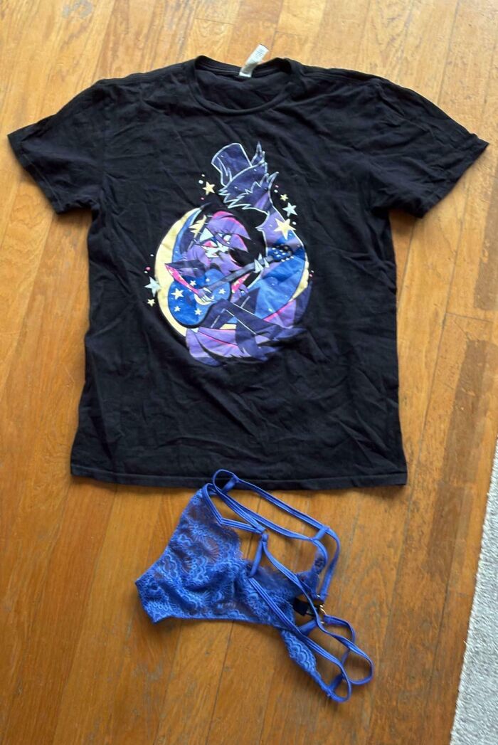 An unhinged Vinted post displaying a black graphic t-shirt and blue lace underwear on a wooden floor.