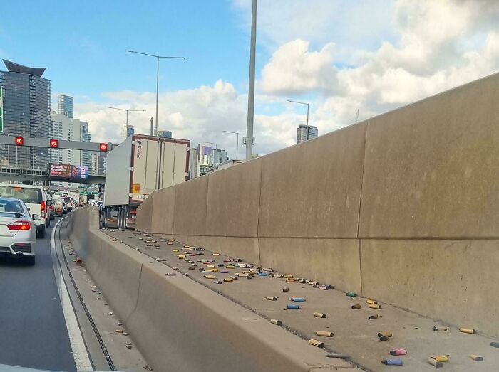A bizarre thing: a highway median littered with numerous colorful, discarded cigar wrappers, an odd sight on the road.