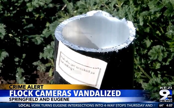 A chaotic good post showing a vandalized Flock camera with a note, inspiring you to be the hero everyone needs.
