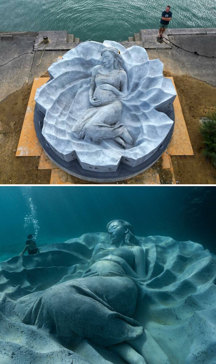 Large pregnant woman underwater sculpture placed on the ocean floor, supporting marine life.