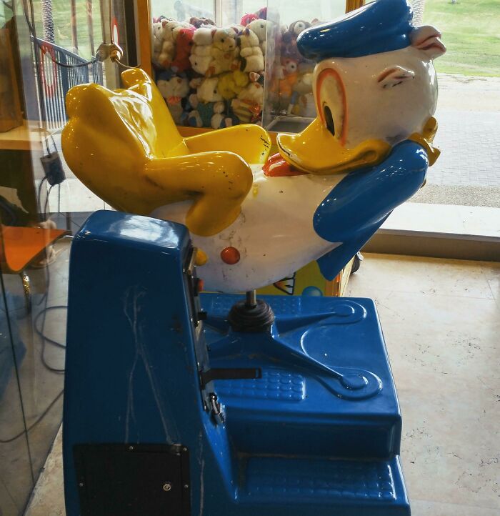 A worn Donald Duck children's ride, showing clear playground fails in its design and condition.