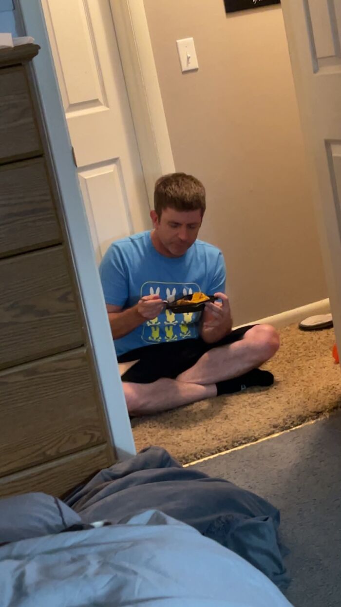 A man sitting on the floor, eating from a small dish, a sweet proof he's the right man.