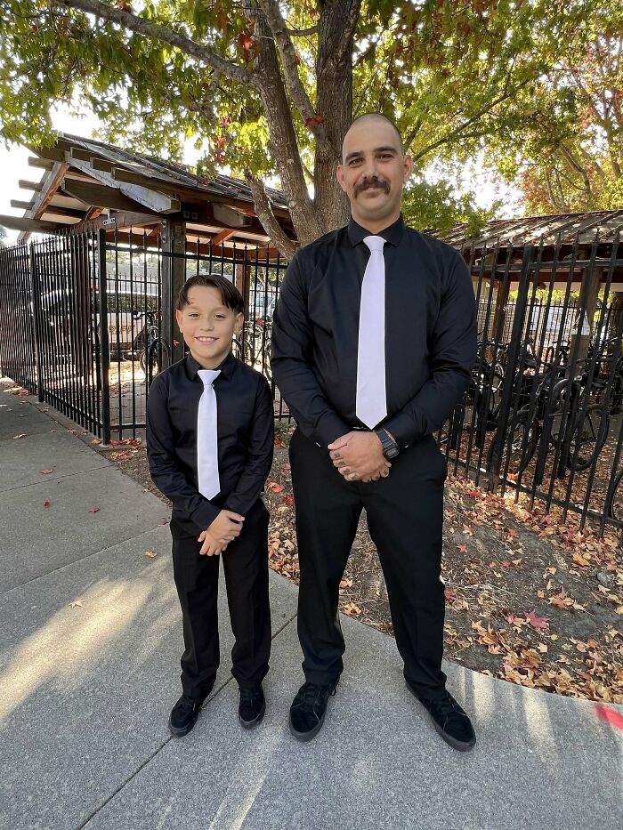 A father and son in matching black shirts and white ties, sweet proof of finding the right man.