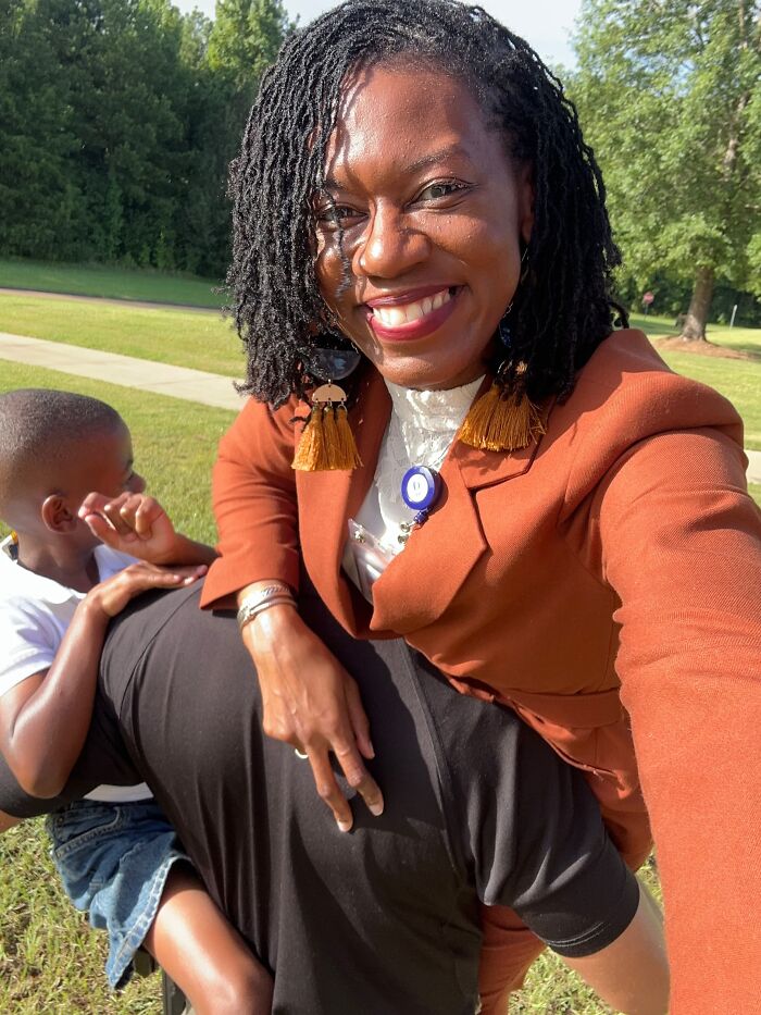 A woman smiling while holding her child on a man's shoulders, proof of finding the right man.
