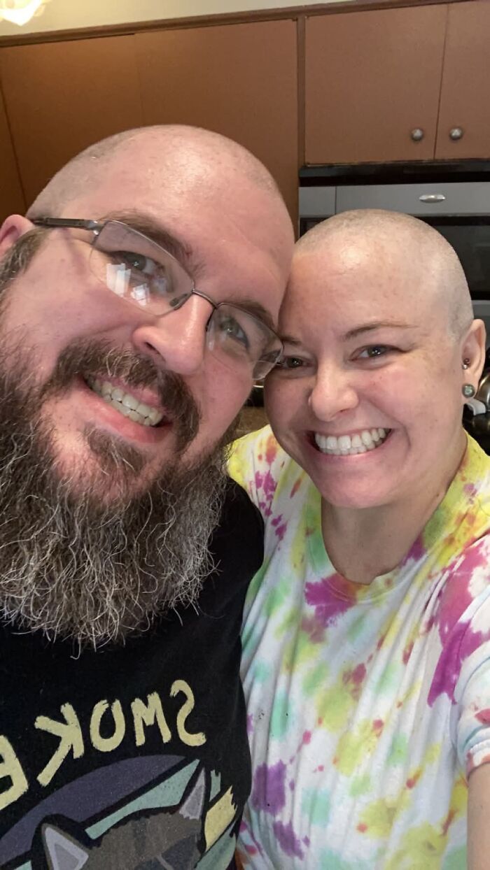 A happy couple, bald, smiling together, a sweet proof they found the right man.