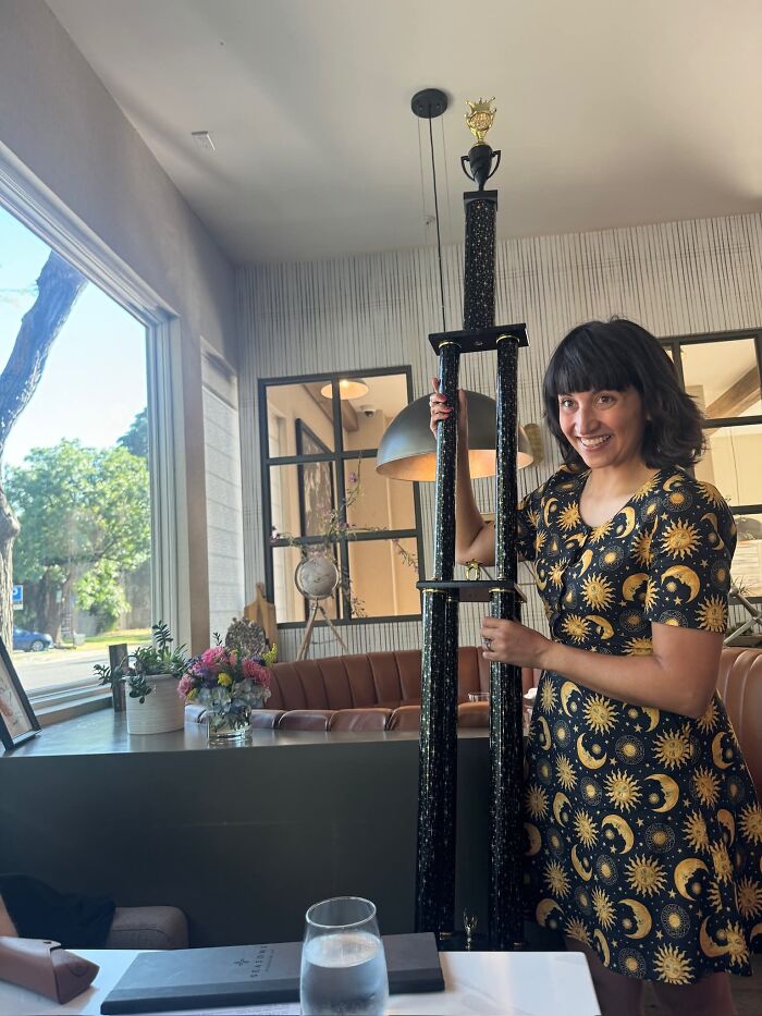 A woman proudly holding a giant trophy, sweet proof she found the right man for celebration.