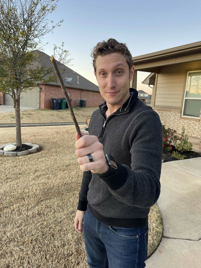 A man holds a stick like a wand, making his partner feel he's the right man.