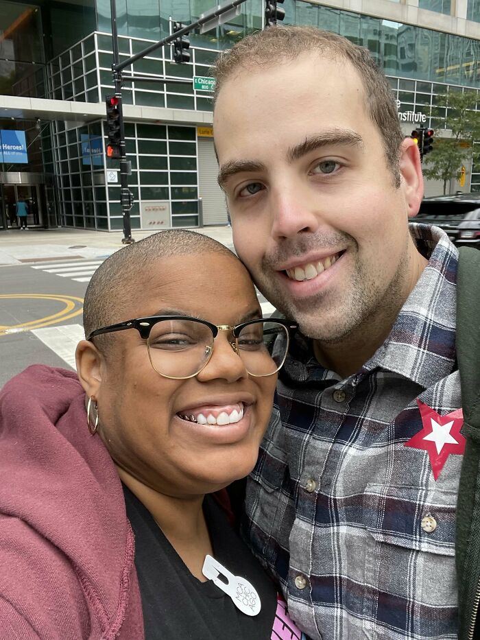 A couple smiles together on a city street, showing proof they found the right man.