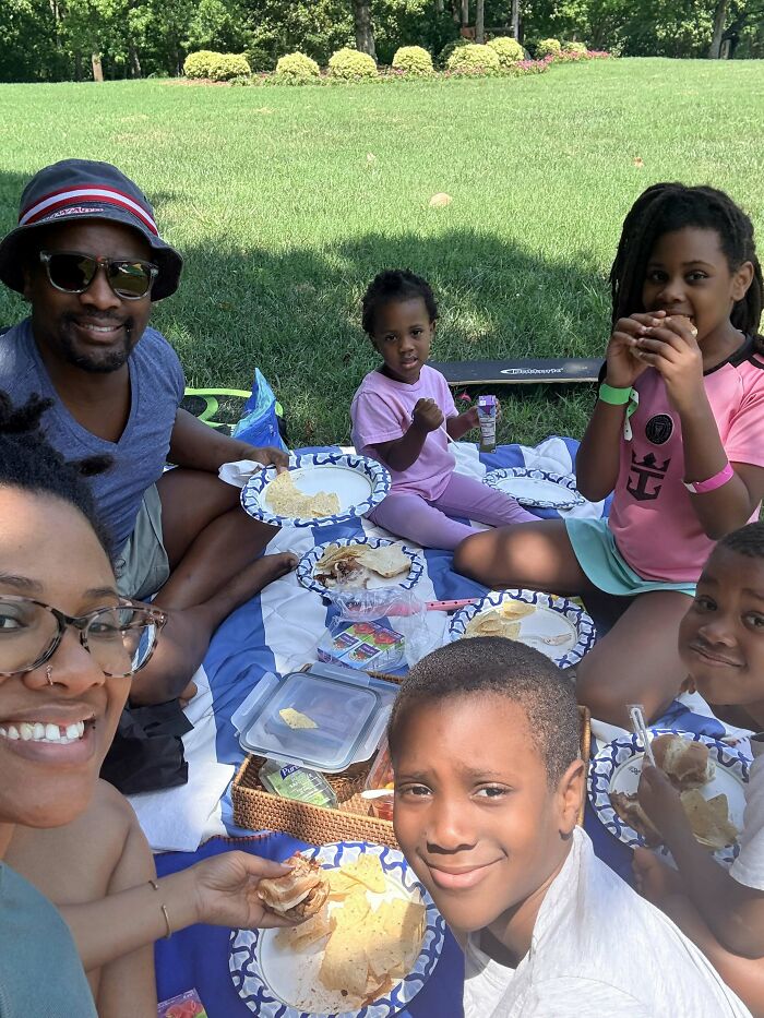 A family enjoys a picnic in a park, showing proof they found the right man.