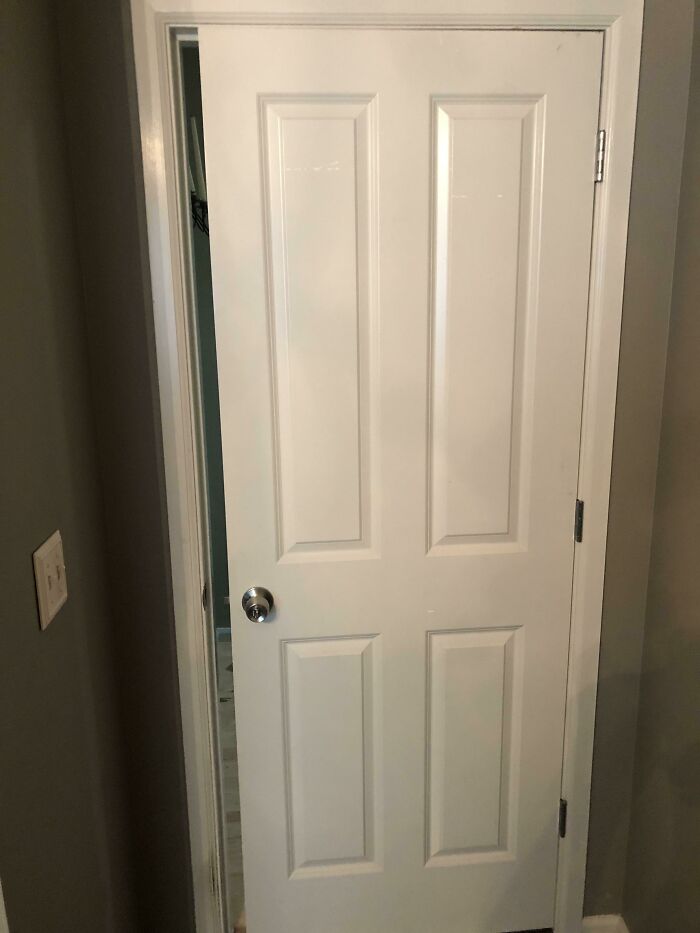 A white door installed improperly, unable to close fully, a clear example of questionable home improvement projects.