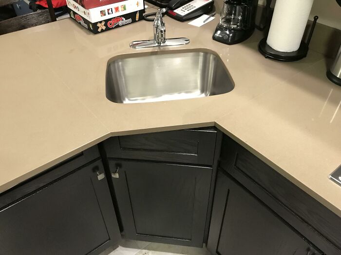 Questionable results from a home improvement project showing a kitchen sink oddly placed in a corner.