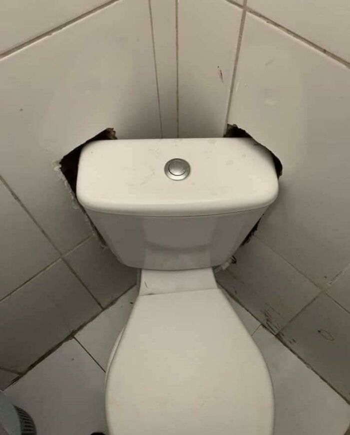 Questionable results from a home improvement project: a toilet with tiles broken around its tank.