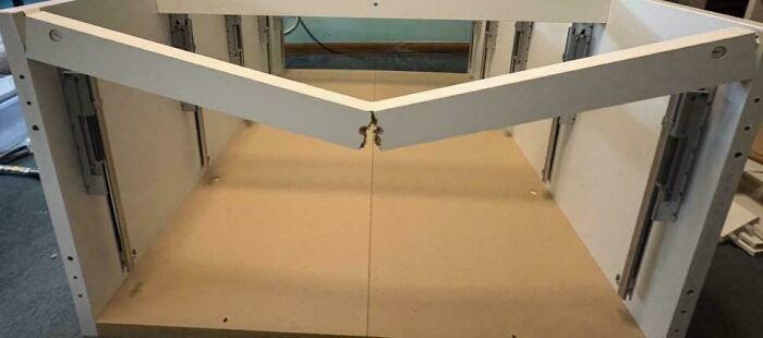 An incorrectly assembled cabinet frame with a broken cross-support, showcasing questionable home improvement results.