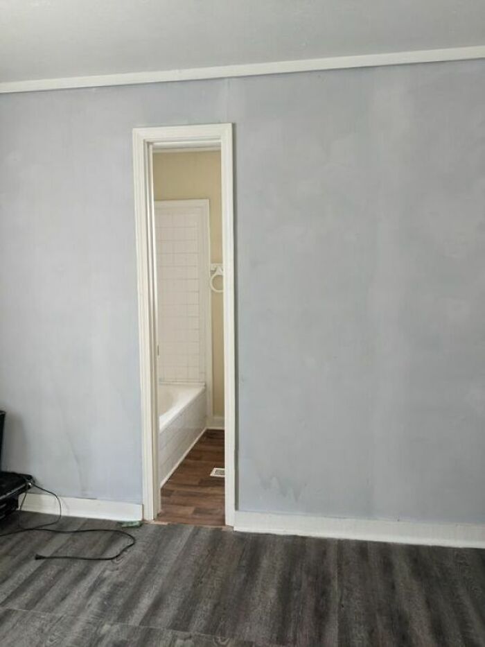 An indoor home improvement room with an off-center doorway leading to a bathroom, highlighting questionable results.