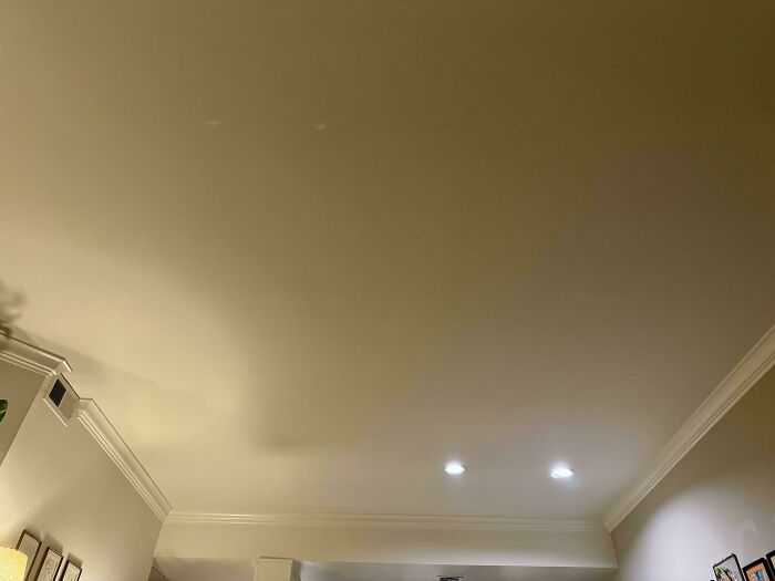 A ceiling with noticeable stains and uneven texture, highlighting questionable home improvement projects.