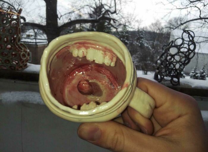 A ceramic mug shaped like an open mouth with teeth, an unhinged secondhand find.
