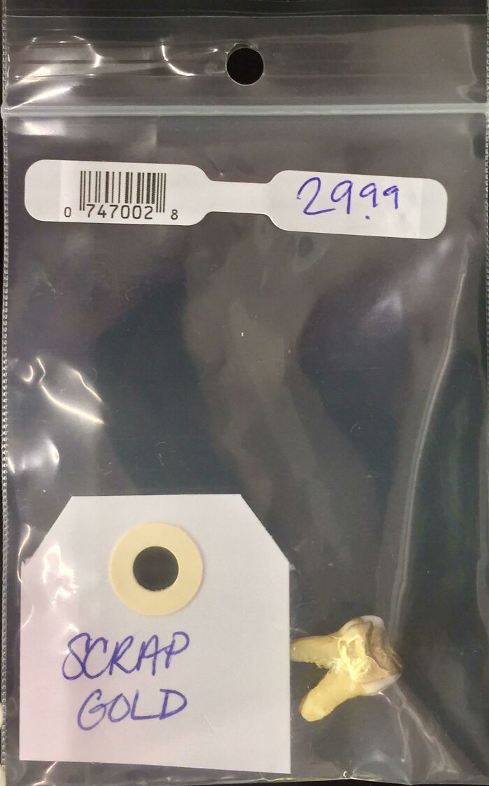 A human tooth labeled as scrap gold in a plastic bag, an unhinged secondhand find.