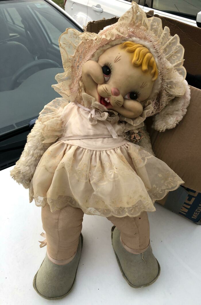 A creepy, oversized vintage bunny doll with a lace bonnet and dress, a truly unhinged secondhand find.