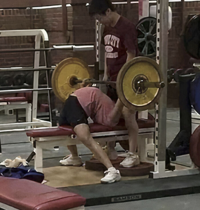 Hilarious photo of someone bench pressing with the barbell behind their head, showcasing internet humor.