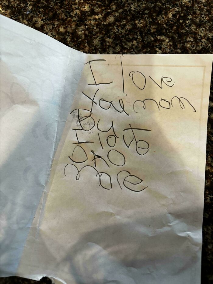 A handwritten note from mischievous kids on a crumpled paper saying I love you mom, but I did it, no more, making parents both laugh and get a headache.