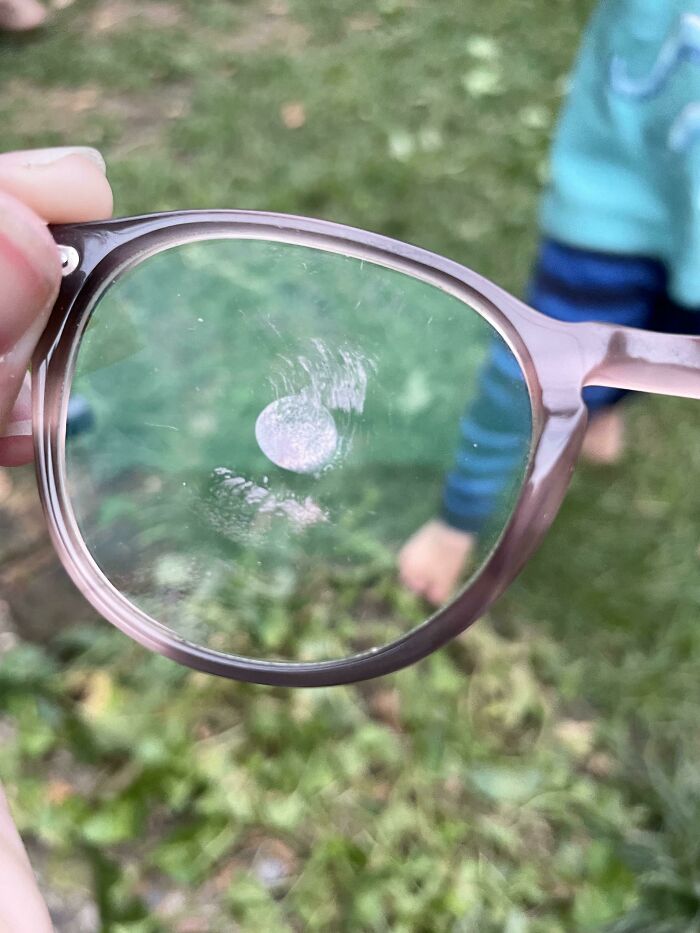 A pair of glasses with a sticky fingerprint on the lens, a common result of mischievous kids.
