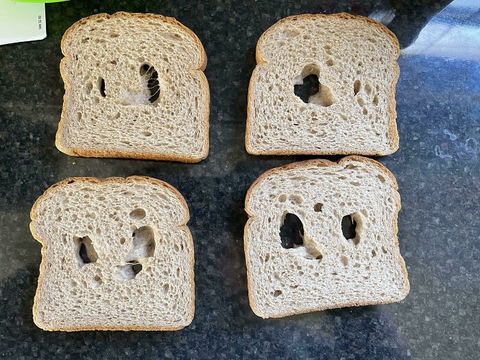Four slices of bread with holes in them, likely from mischievous kids playing with food.