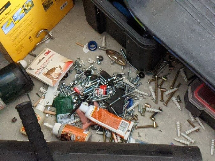 A messy floor with various screws, bolts, and tools spilled, showcasing the chaos mischievous kids can create.