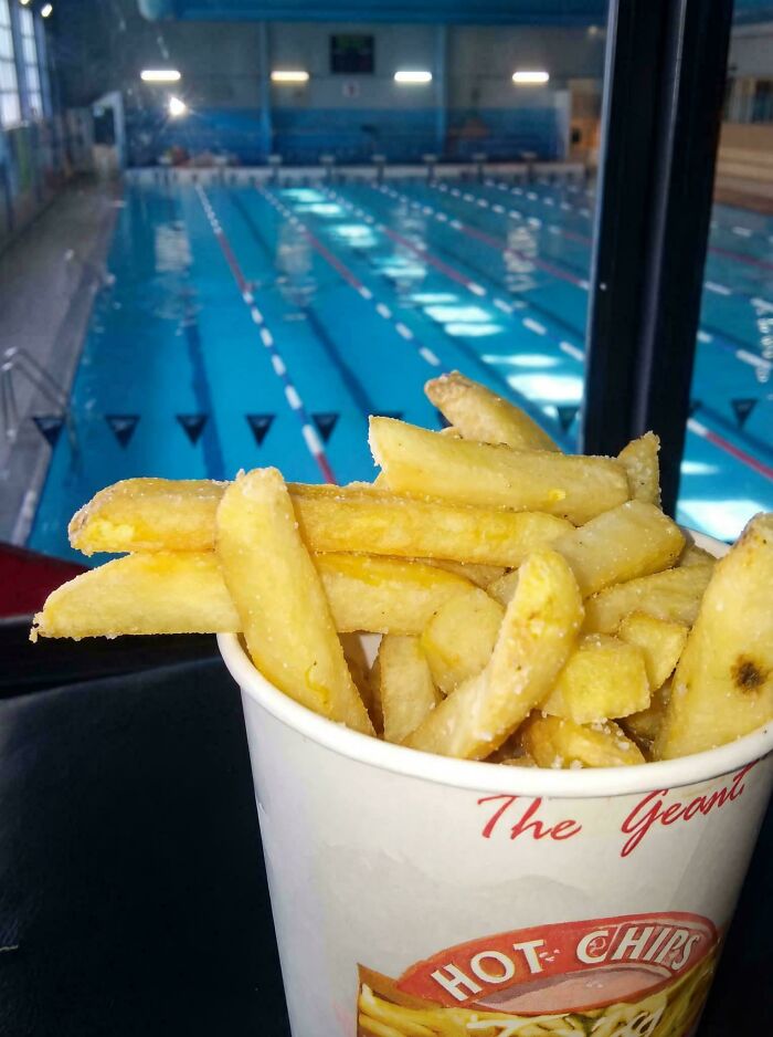 A cup of hot chips overlooking a swimming pool, a nostalgic Aussie memory.