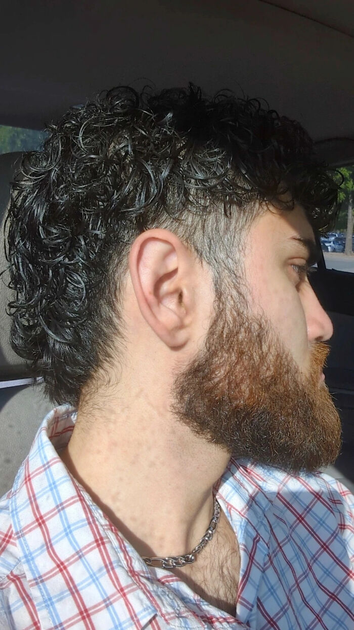 A man with curly hair on top and shaved sides, displaying a unique body quirk.