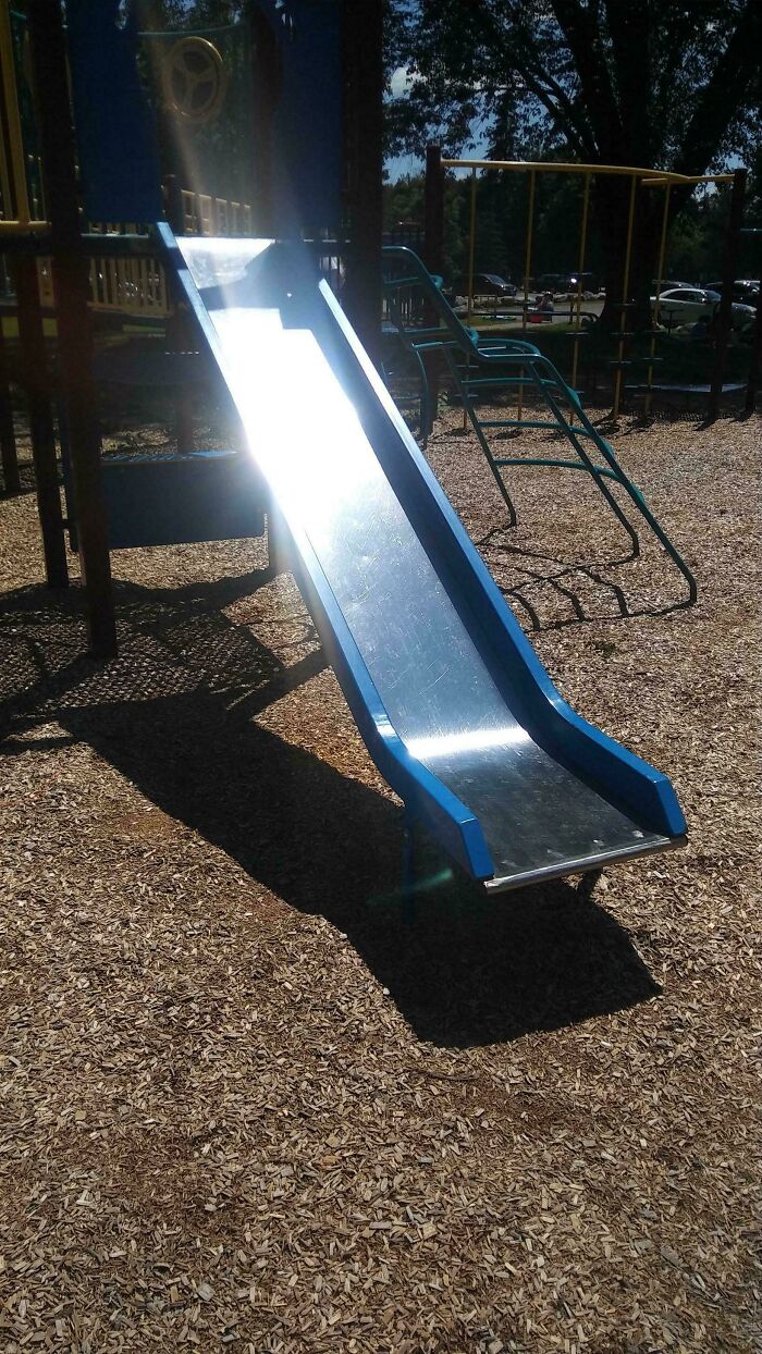 A slide at a playground, gleaming under the sun, evoking nostalgic Aussie memories of childhood.
