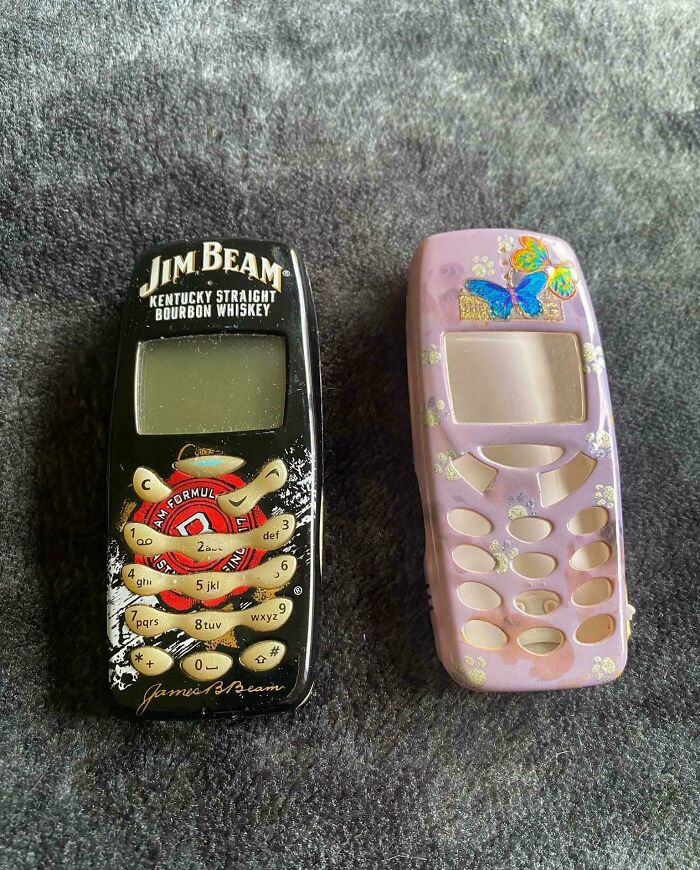 Nostalgic Aussie memories of two old mobile phones, one black Jim Beam branded and one purple with butterflies.