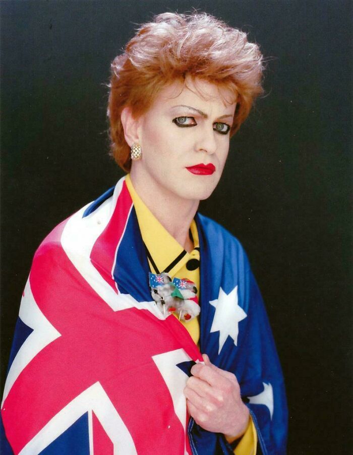 Person with flamboyant red hair wrapped in an Australian flag, capturing nostalgic Aussie memories.