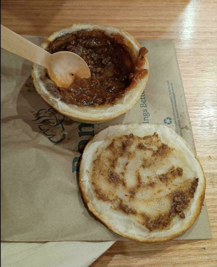A meat pie with its lid removed, a spoonful of filling, a classic food that brings back nostalgic Aussie memories.