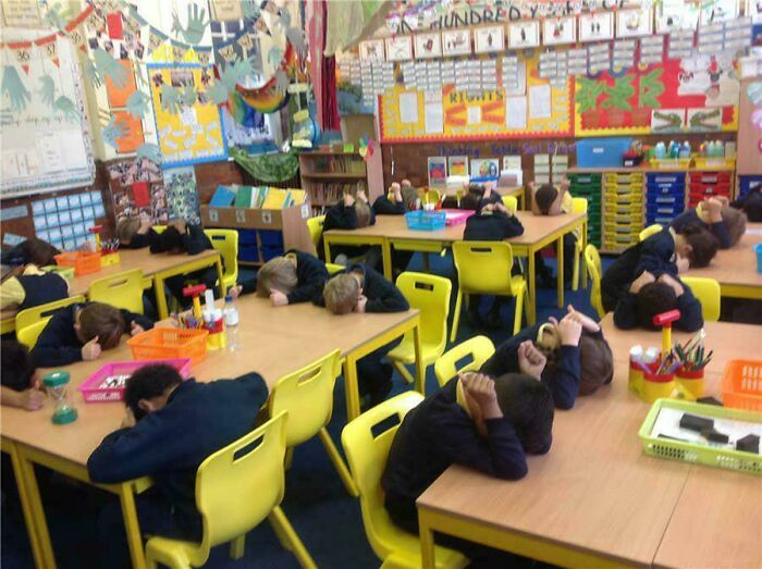 A classroom of children resting their heads on desks, a common sight that brings back nostalgic Aussie memories.