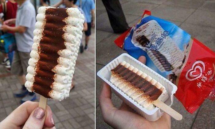 A hand holding a chocolate and vanilla ripple ice cream bar, evoking Aussie memories.
