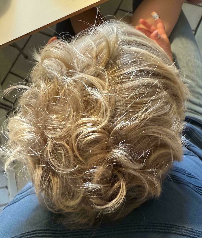 Overhead view of a person with curly blonde hair, showcasing a unique body quirk.