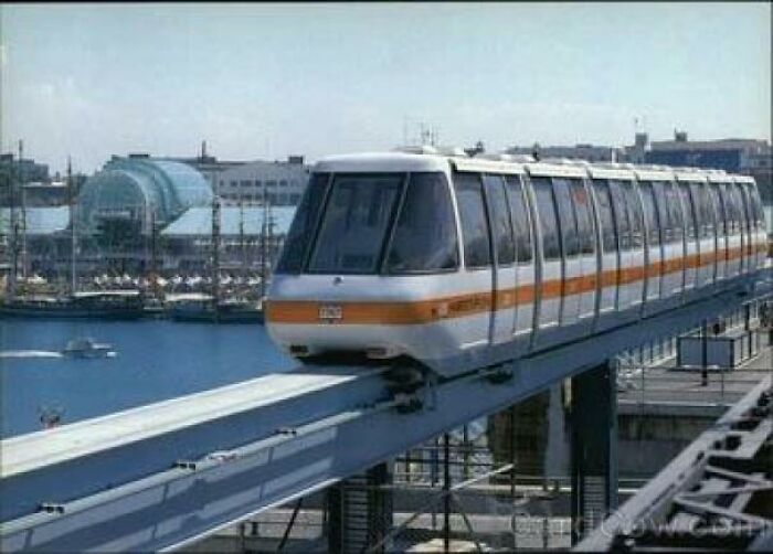 A monorail train traveling on an elevated track above a harbor, a nostalgic Aussie memory of urban transport.