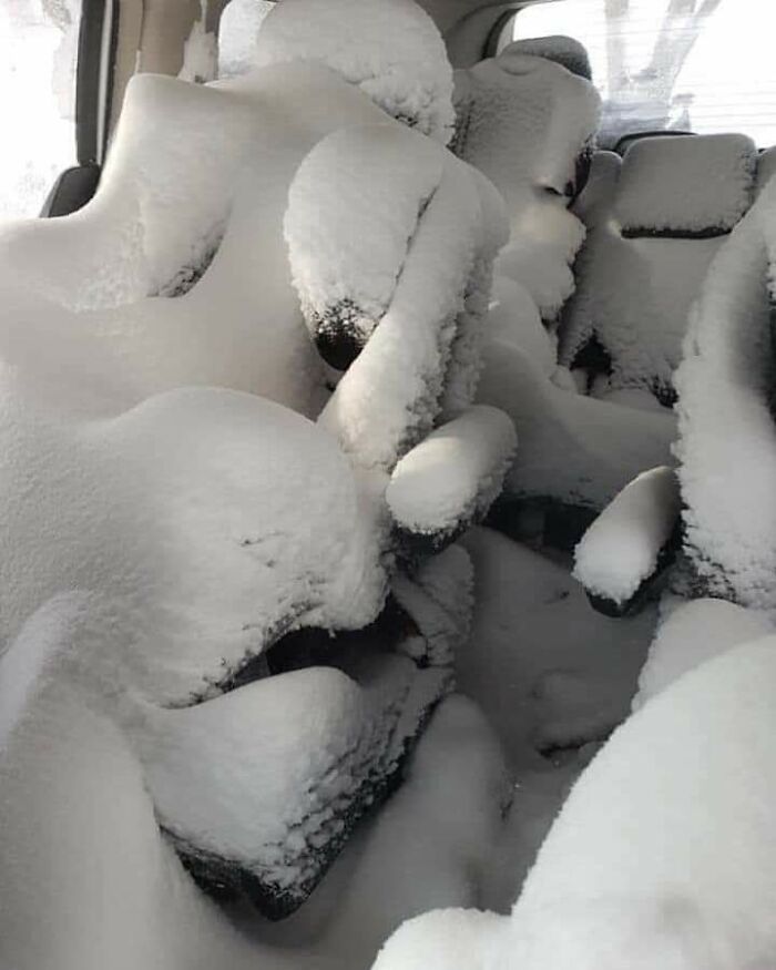 Car interior seats covered in deep snow, a result of hilarious and mischievous kids playing.