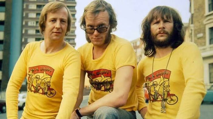 Three men wearing yellow T-shirts with cartoon characters, evoking nostalgic Aussie memories.